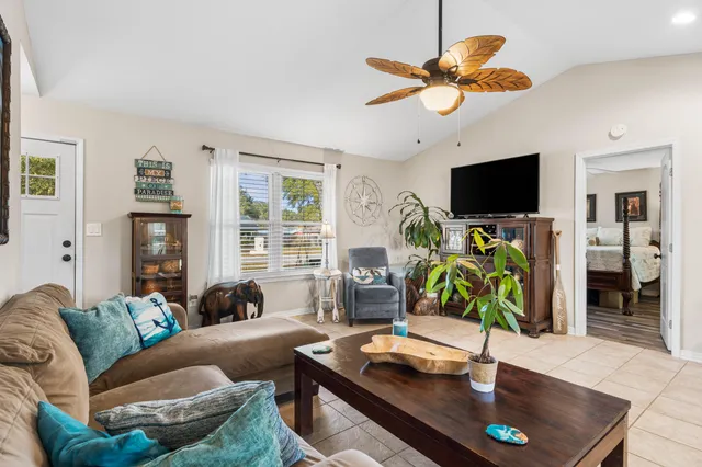 a living room with furniture a flat screen tv and a large window