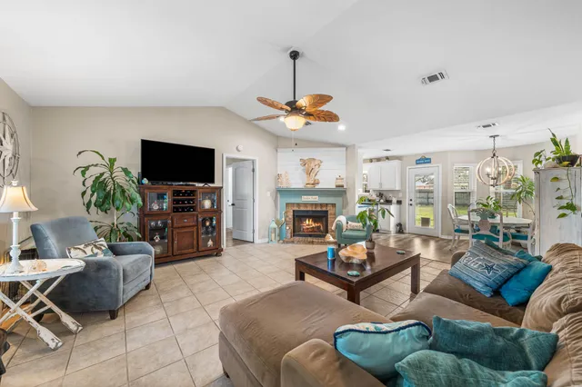 a living room with furniture a flat screen tv and a fireplace