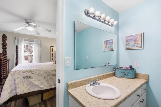 a bathroom with a granite countertop sink a mirror and shower