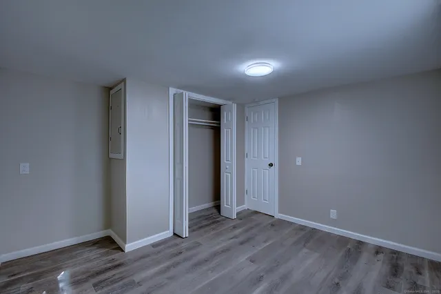 an empty room with wooden floor and closet