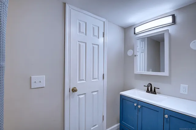 a bathroom with a sink a toilet and a mirror