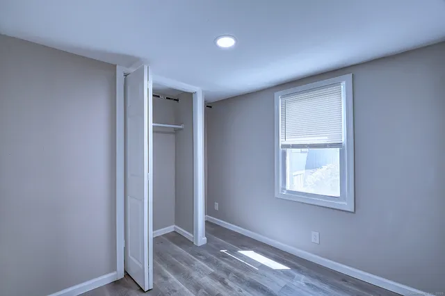 a view of an empty room with wooden floor