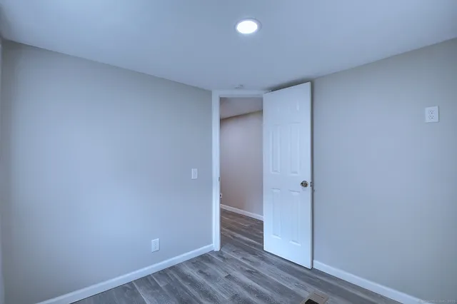 a view of hallway with a window and wooden floor