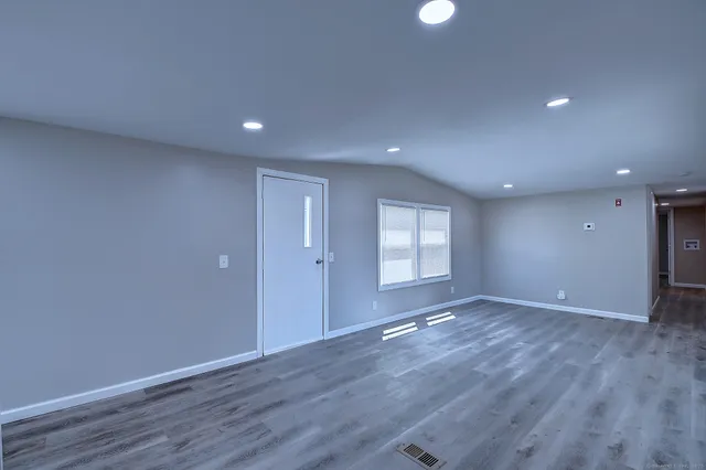 a view of an empty room with wooden floor