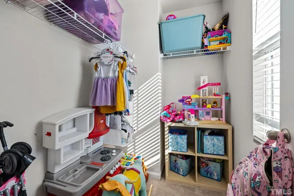 a bed sitting in a spacious bedroom next to a window