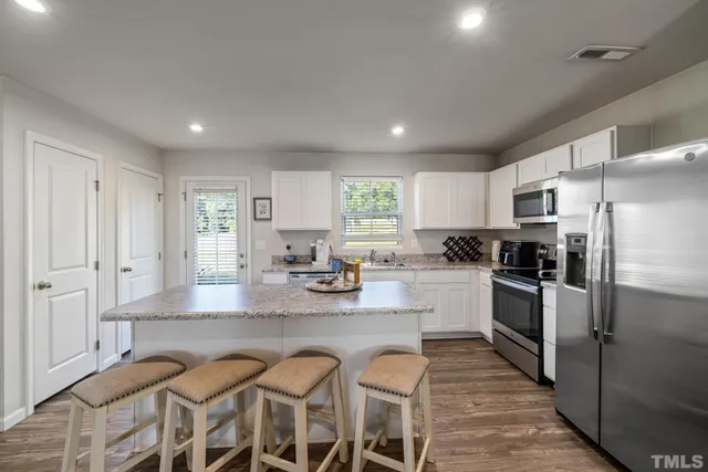 a large kitchen with lots of counter space and stainless steel appliances