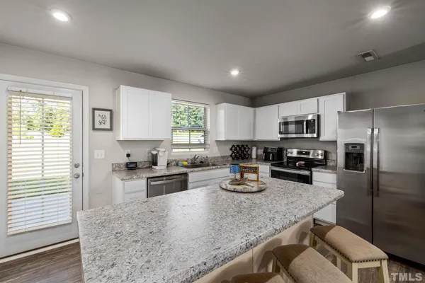 a kitchen with refrigerator cabinets and windows