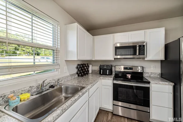 a kitchen with a sink a stove and microwave