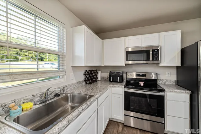 a kitchen with a sink a stove and microwave