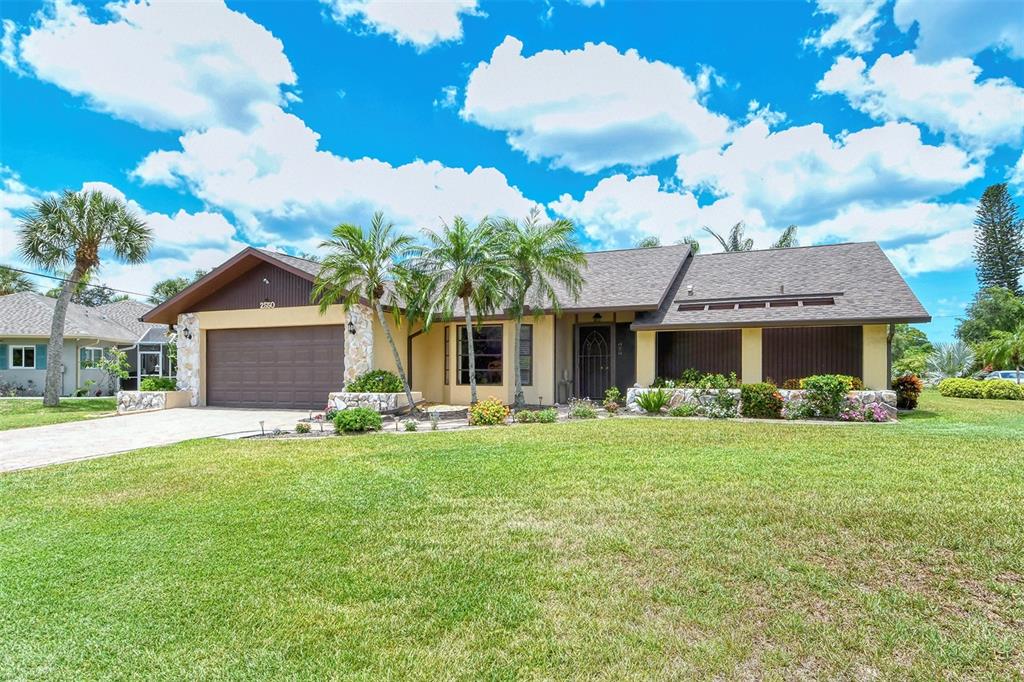 2550 Rigel Road Venice, FL 34293 - Photo 1 of 1 a front view of a house with a garden and trees