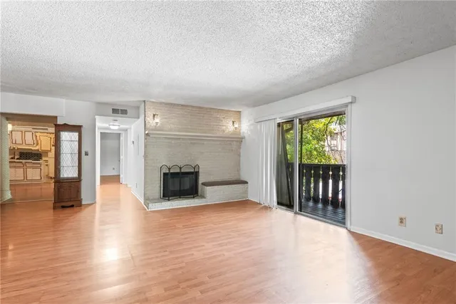 an empty room with wooden floor and a fireplace