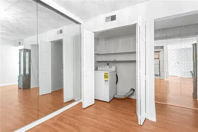 a view of empty room with wooden floor