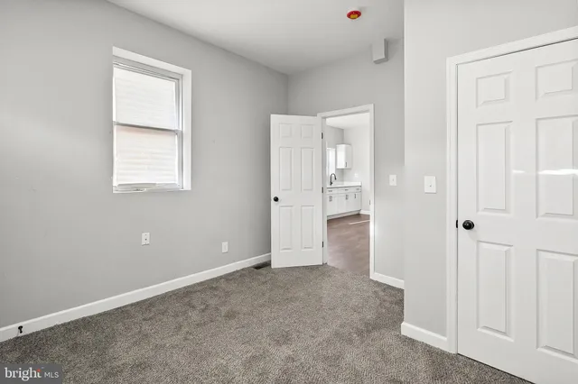 an empty room with windows and closet