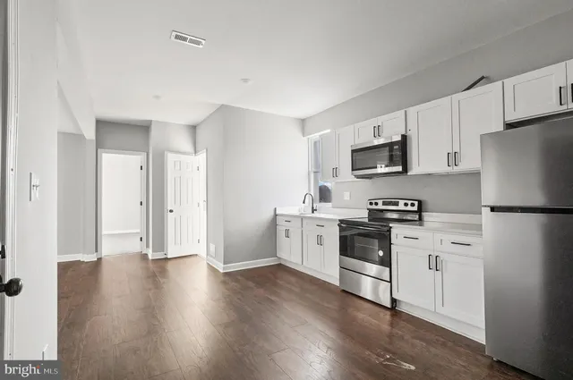 a kitchen with white cabinets and stainless steel appliances