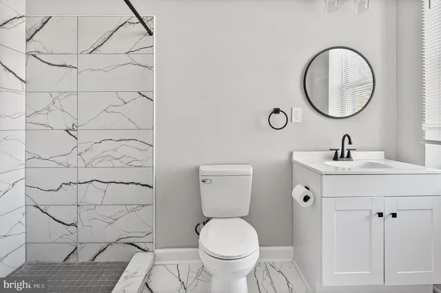 a bathroom with a toilet sink and a mirror