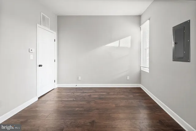 a view of an empty room with wooden floor
