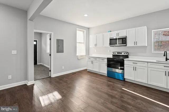 a kitchen with granite countertop white cabinets and black appliances