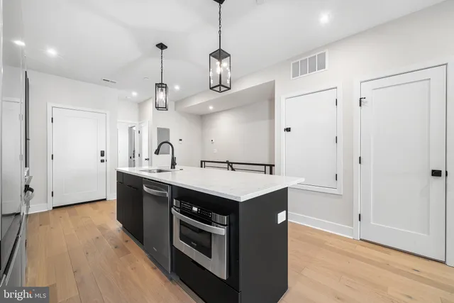 a kitchen with kitchen island a sink a stove a refrigerator and a window