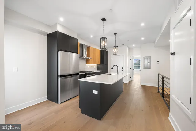 a large kitchen with stainless steel appliances kitchen island a refrigerator a stove a sink and a microwave