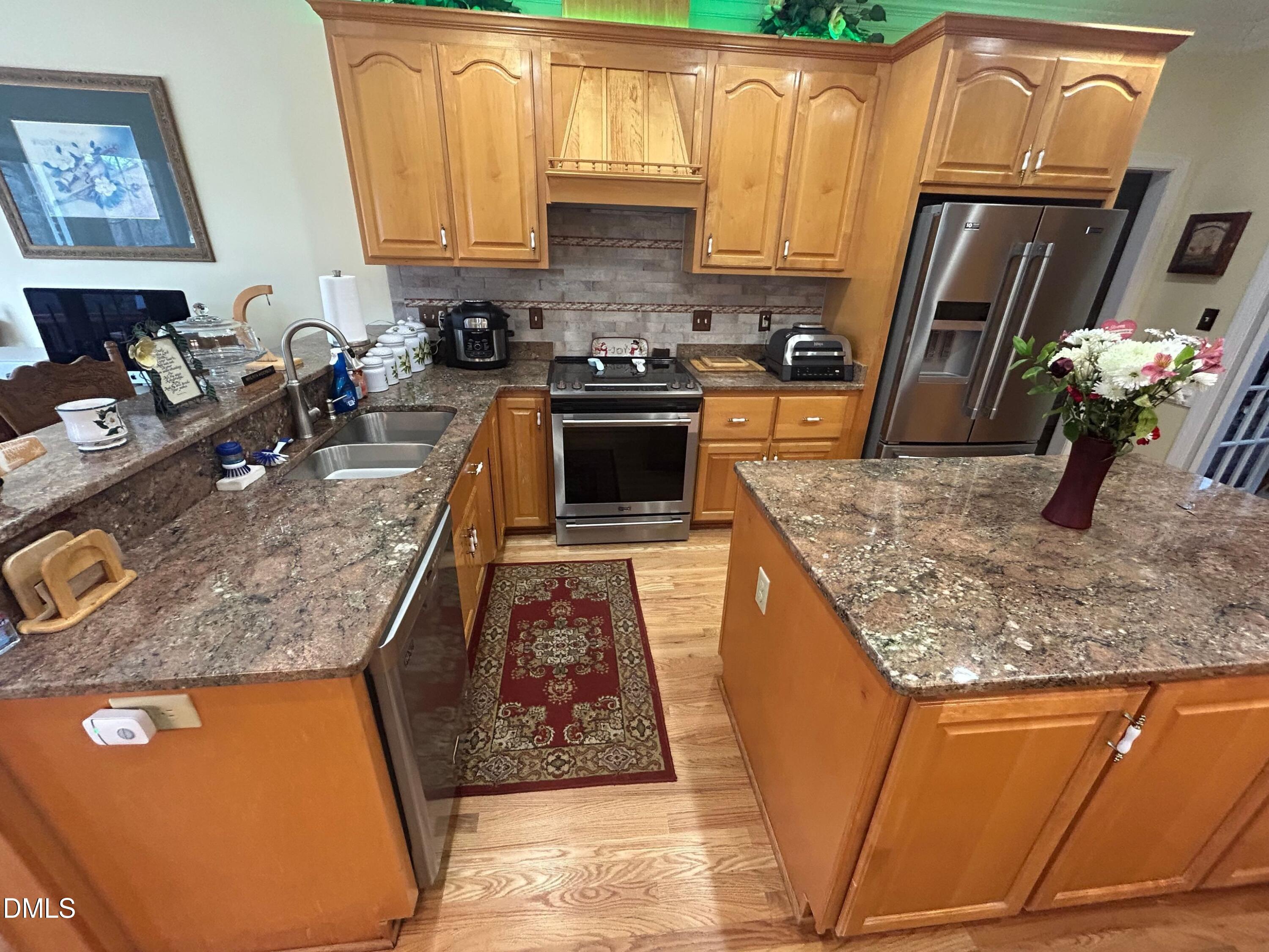 3608 Pauley Court Raleigh, NC 27610 - Photo 19 of 48 a kitchen with kitchen island granite countertop a sink stove and refrigerator