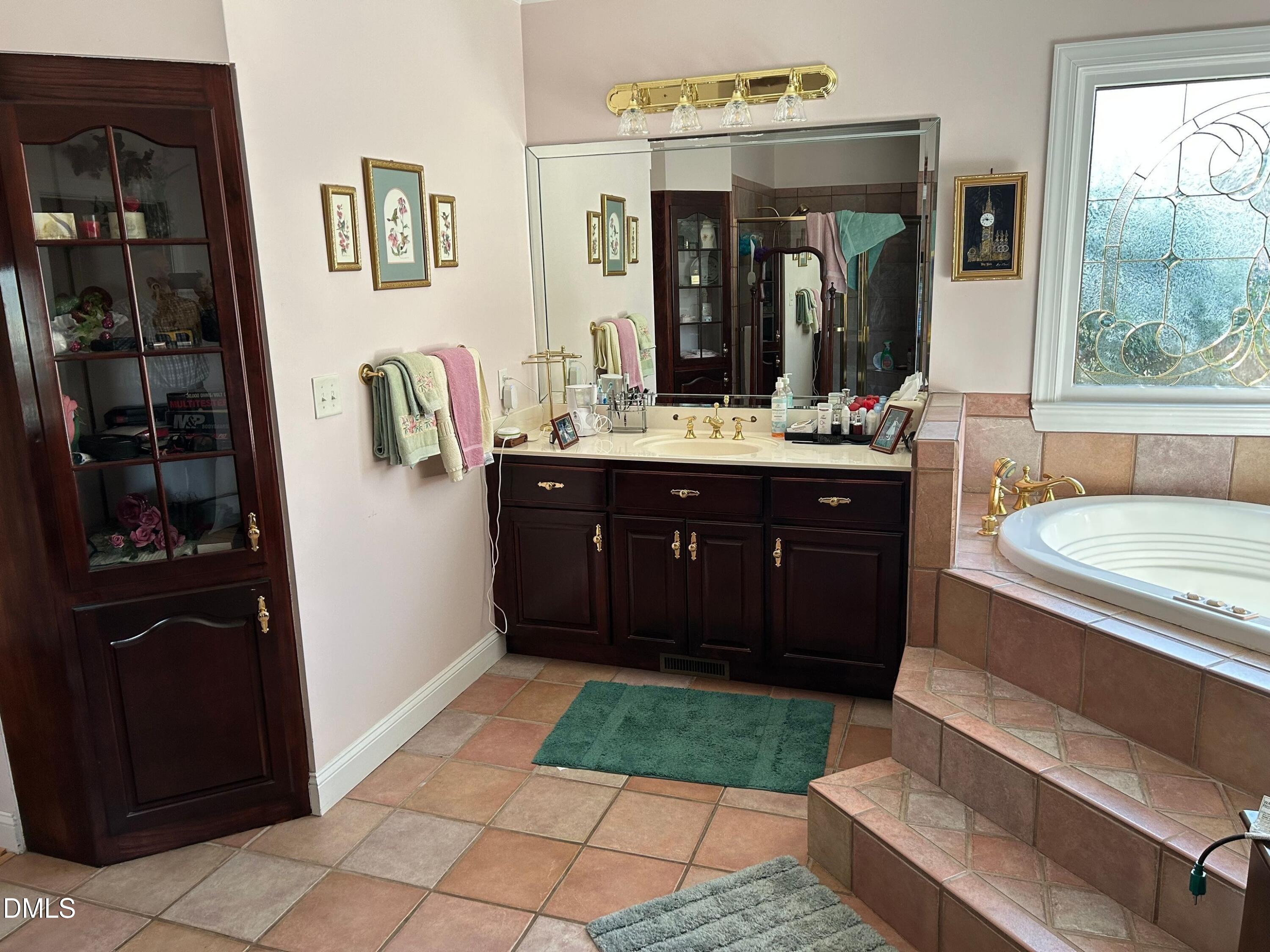 3608 Pauley Court Raleigh, NC 27610 - Photo 36 of 48 a spacious bathroom with a bathtub sink and mirror