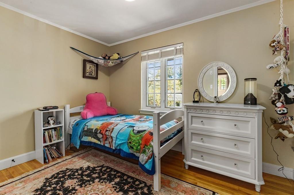 132 Beverly Road Brookline, MA 02467 - Photo 14 of 36 a bedroom with a bed a dresser and a window