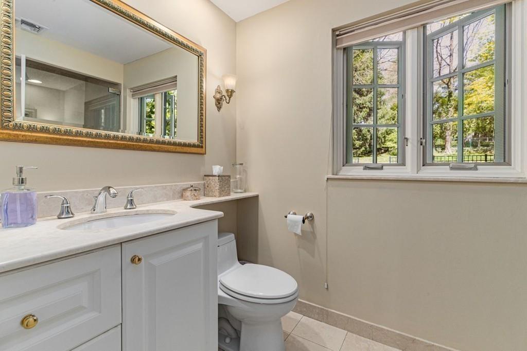 132 Beverly Road Brookline, MA 02467 - Photo 21 of 36 a bathroom with a granite countertop toilet sink and mirror