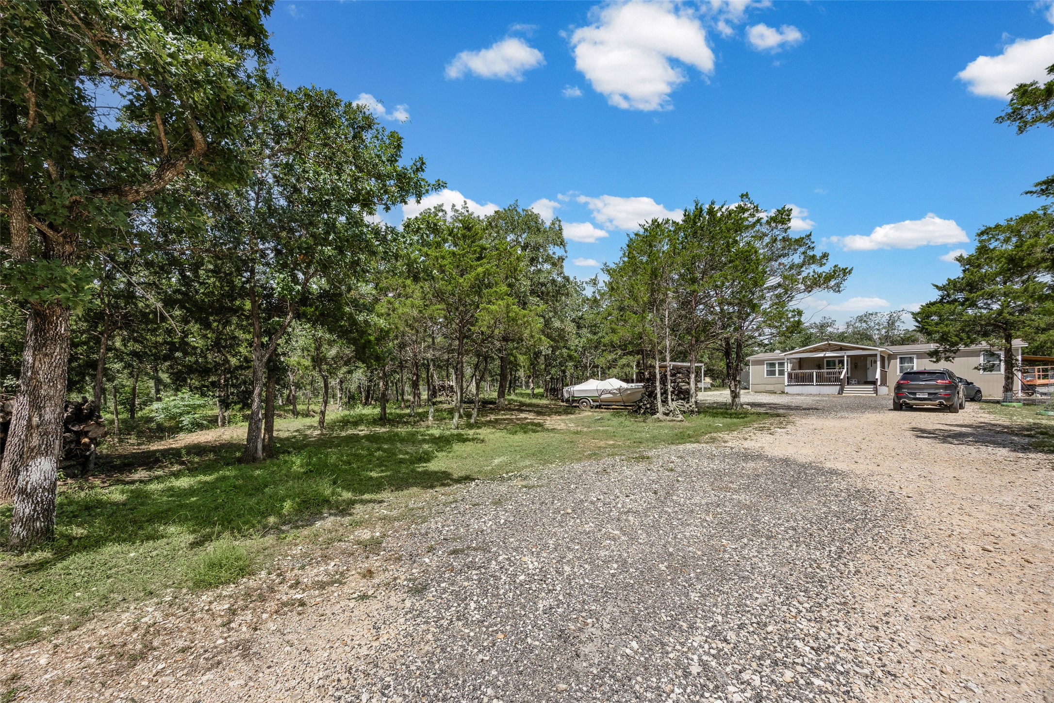 564 Boyd Road Red Rock, TX 78662 - Photo 25 of 25 A long gravel driveway leads to a modest home nestled among a grove of mature trees.