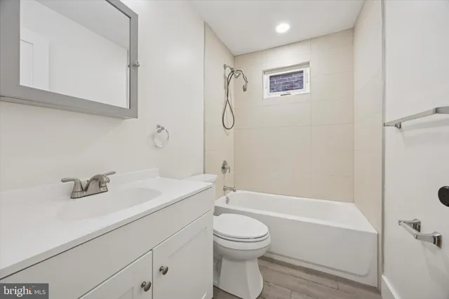 a bathroom with a granite countertop sink a toilet and shower