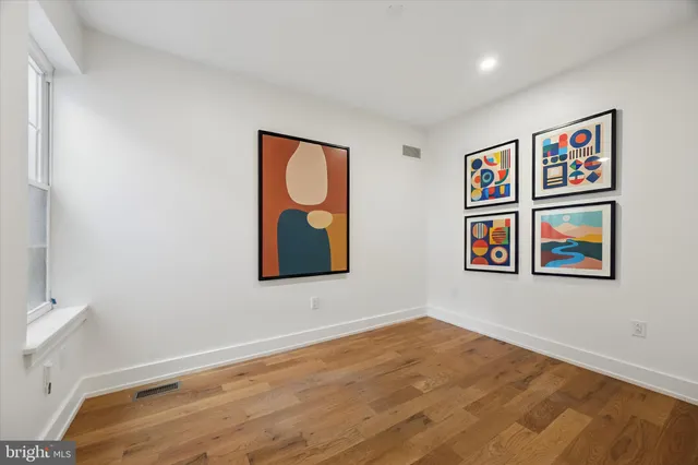a room with painting on the wall and wooden floor