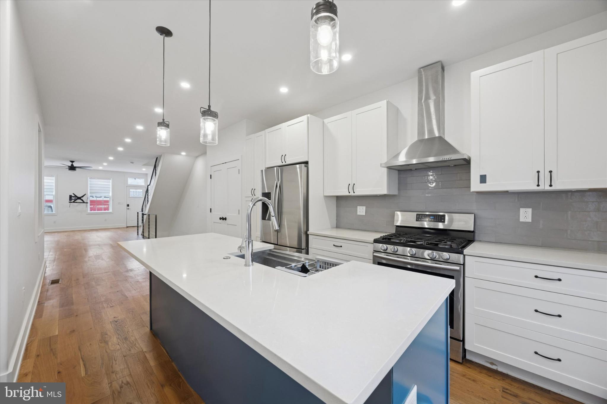 531 Mifflin Street Philadelphia, PA 19148 - Photo 9 of 28 a kitchen with stainless steel appliances a stove a sink a refrigerator and white cabinets with wooden floor