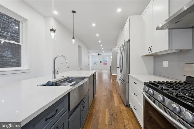 a kitchen with stainless steel appliances granite countertop a stove a sink and a refrigerator