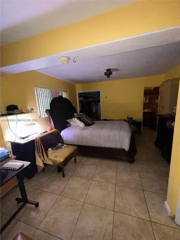 a bedroom with a bed and teddy bear on bed