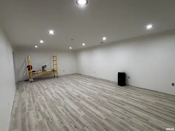 a view of an empty room with wooden floor and closet