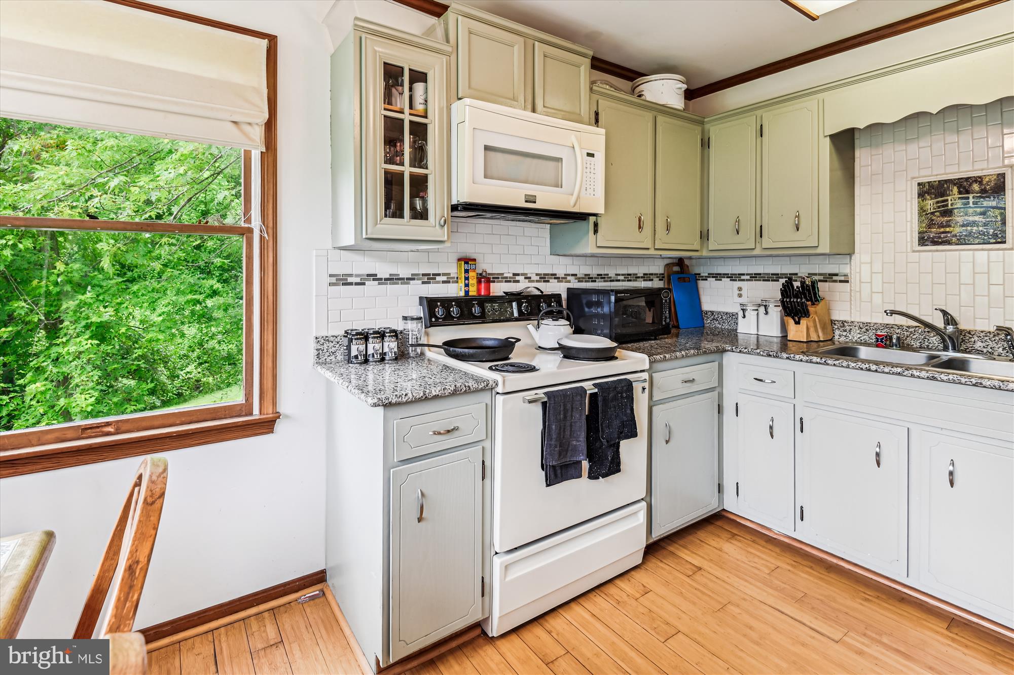 4441 Solomons Island Road Harwood, MD 20776 - Photo 69 of 87 a kitchen with stainless steel appliances white cabinets a sink a stove a microwave and a window