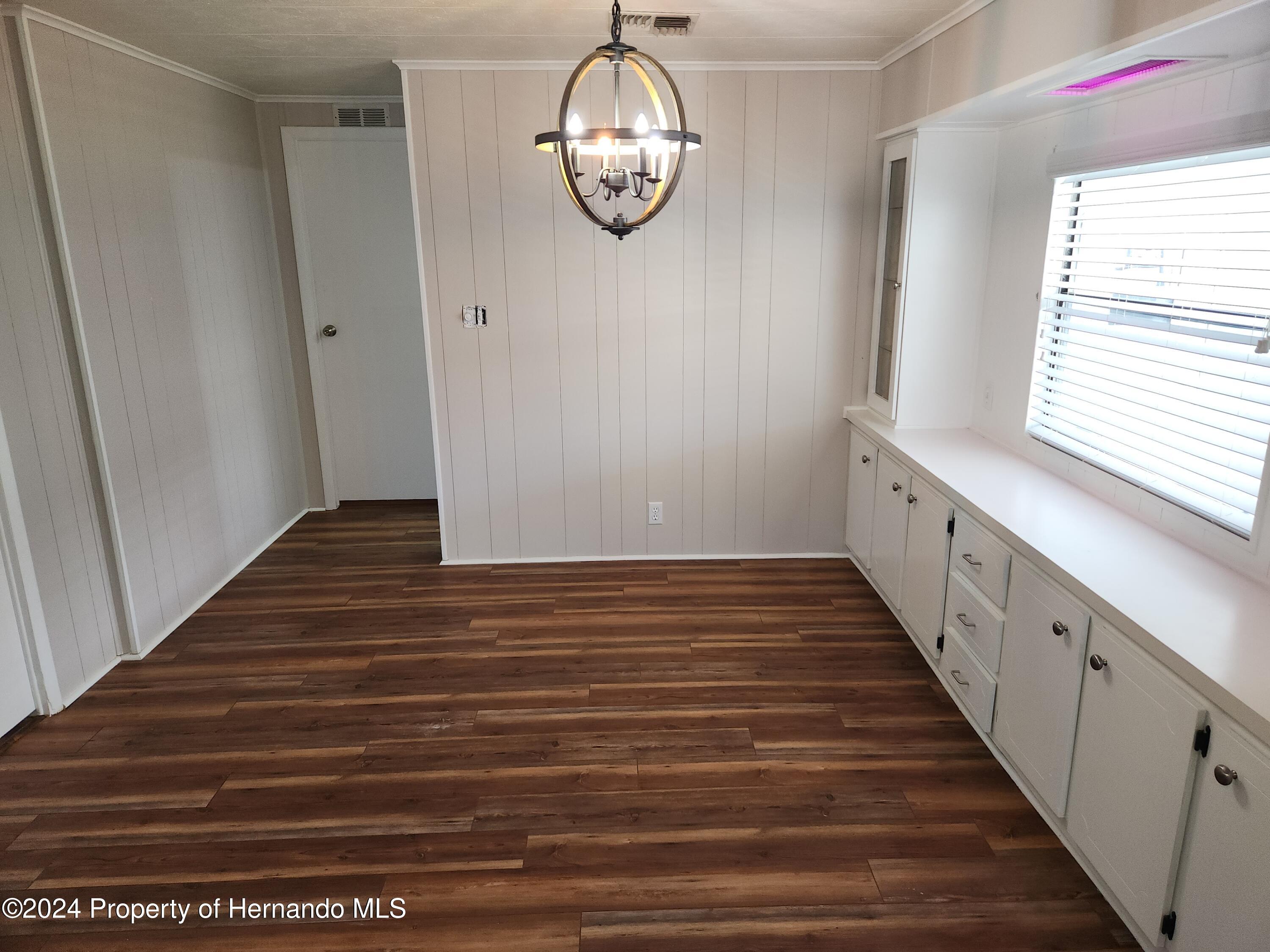 8040 Mission Street Brooksville, FL 34613 - Photo 5 of 17 a view of a hallway with wooden floor and staircase