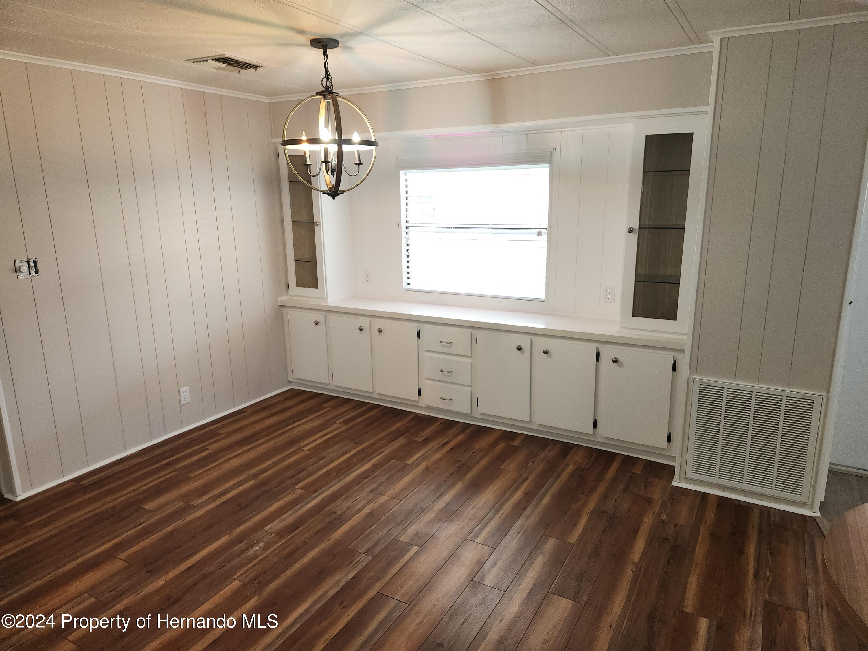 8040 Mission Street Brooksville, FL 34613 - Photo 6 of 17 a view of an empty room with wooden floor and a window
