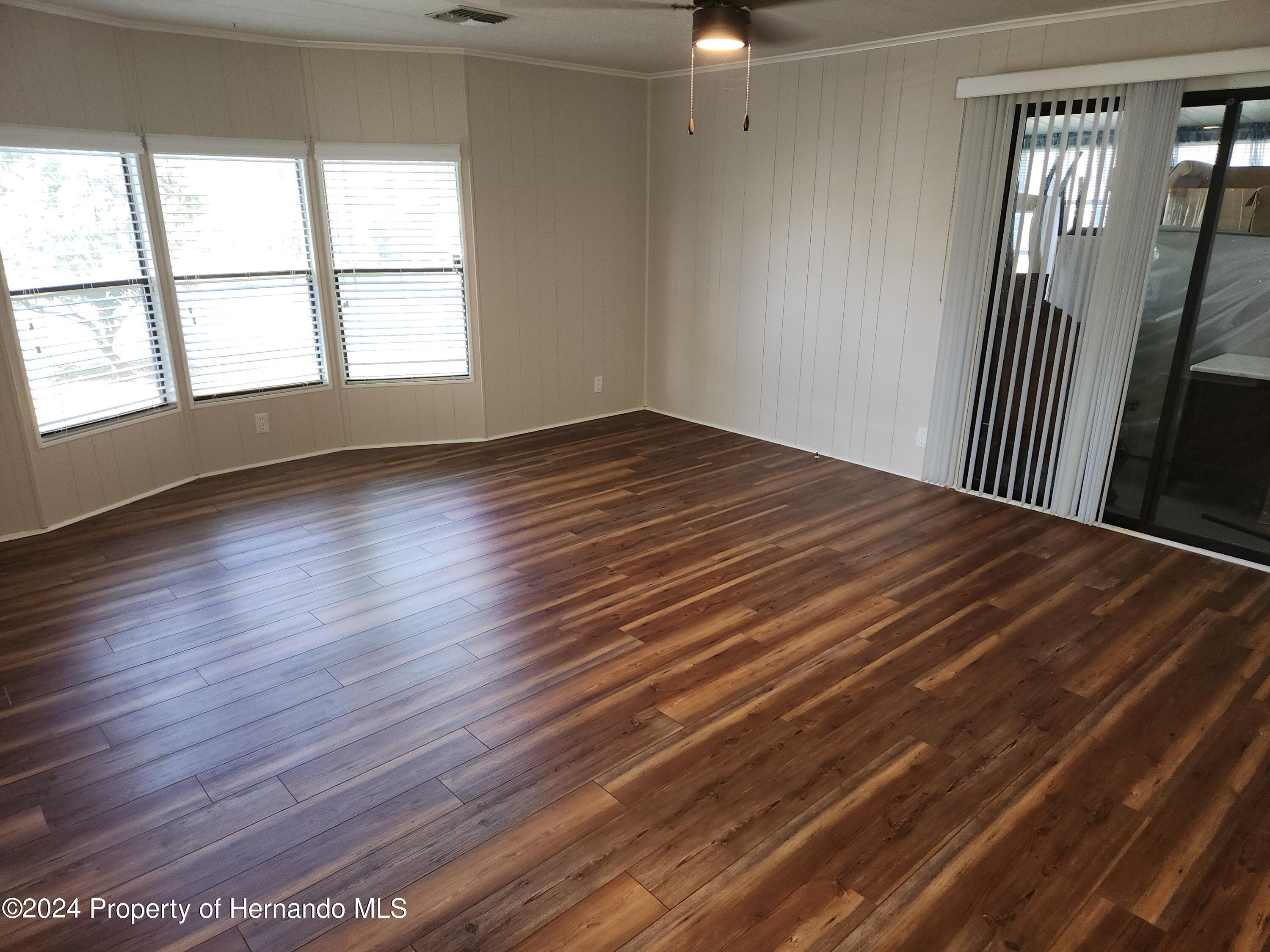 8040 Mission Street Brooksville, FL 34613 - Photo 7 of 17 wooden floor in an empty room with a window