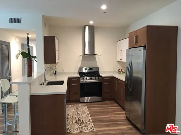 a kitchen with stainless steel appliances granite countertop a refrigerator and a stove