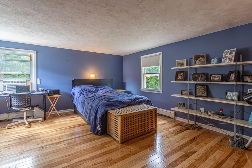 202 Whalom Road Lunenburg, MA 01462 - Photo 17 of 42 a spacious bedroom with a bed and a book shelf