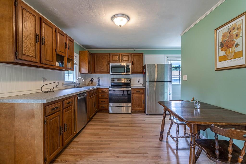 202 Whalom Road Lunenburg, MA 01462 - Photo 4 of 42 a kitchen with stainless steel appliances wooden floors and wooden cabinets