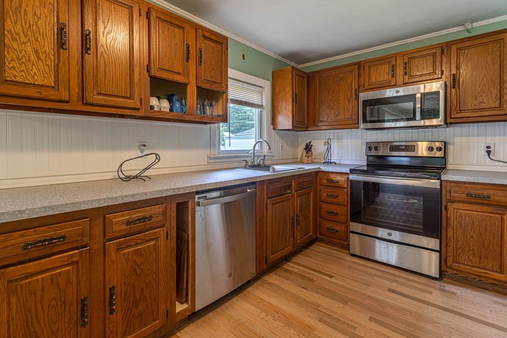 202 Whalom Road Lunenburg, MA 01462 - Photo 7 of 42 a kitchen with stainless steel appliances granite countertop a sink a stove and cabinets