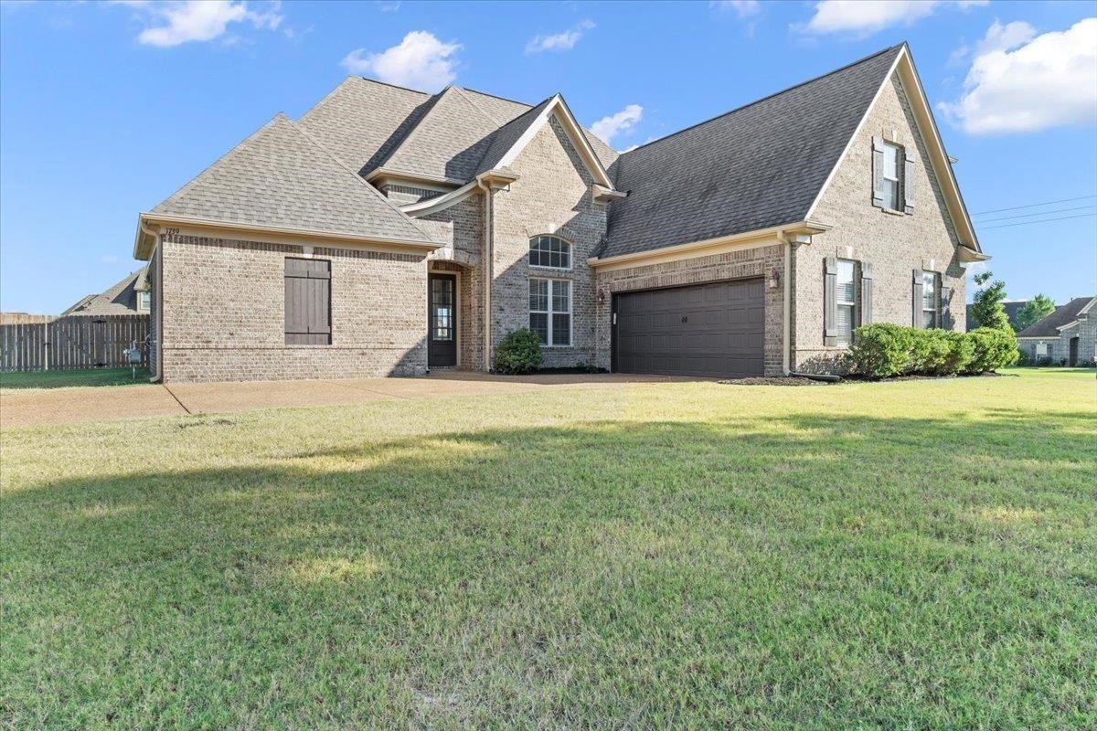 a view of a house with a yard and garage