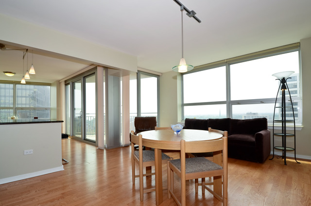807 Davis Street, Unit 1405 Evanston, IL 60201 - Photo 3 of 12 a dining room with furniture a chandelier and wooden floor