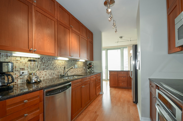 807 Davis Street, Unit 1405 Evanston, IL 60201 - Photo 5 of 12 a kitchen with stainless steel appliances granite countertop a sink and cabinets