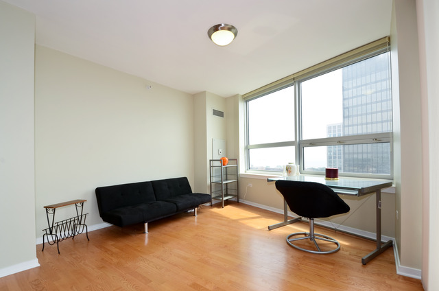 807 Davis Street, Unit 1405 Evanston, IL 60201 - Photo 6 of 12 a living room with furniture a table and chair with wooden floor