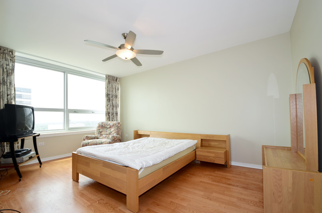 807 Davis Street, Unit 1405 Evanston, IL 60201 - Photo 7 of 12 a bedroom with a bed and a chandelier