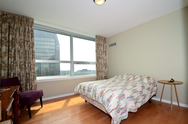 807 Davis Street, Unit 1405 Evanston, IL 60201 - Photo 8 of 12 a bedroom with a bed and a chair