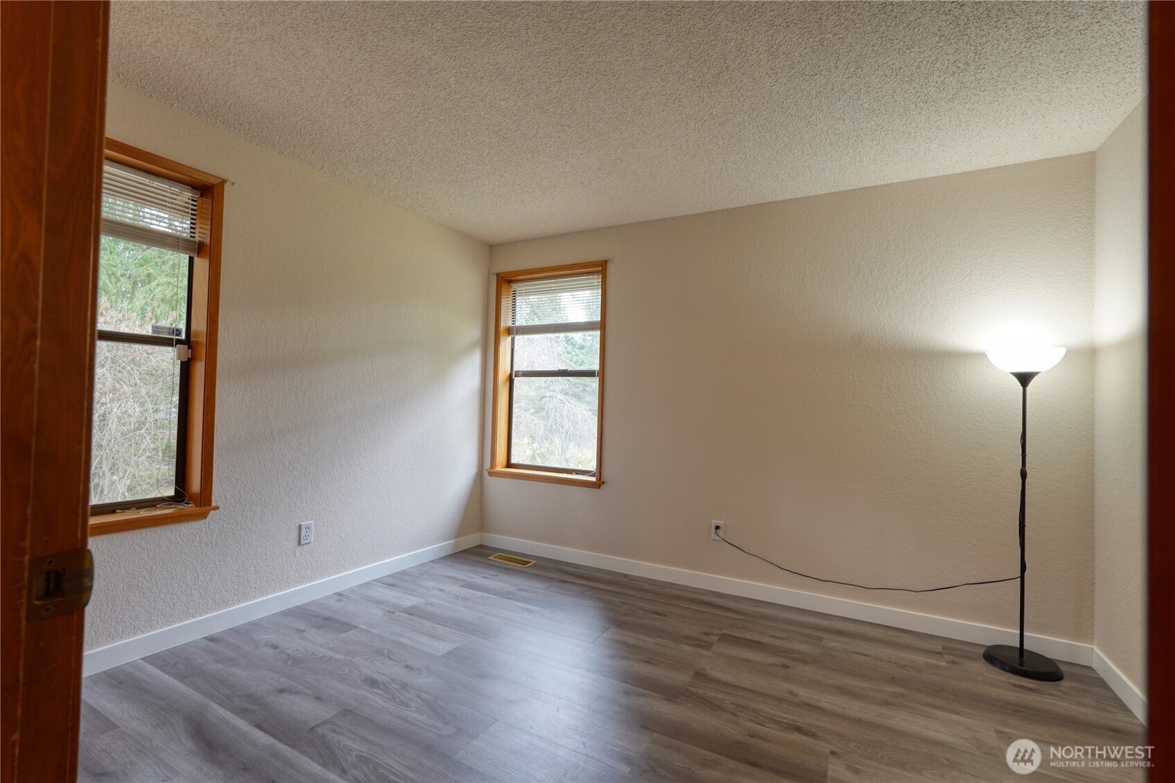 6511 255th St Court East Graham, WA 98338 - Photo 12 of 20 an empty room with wooden floor and windows