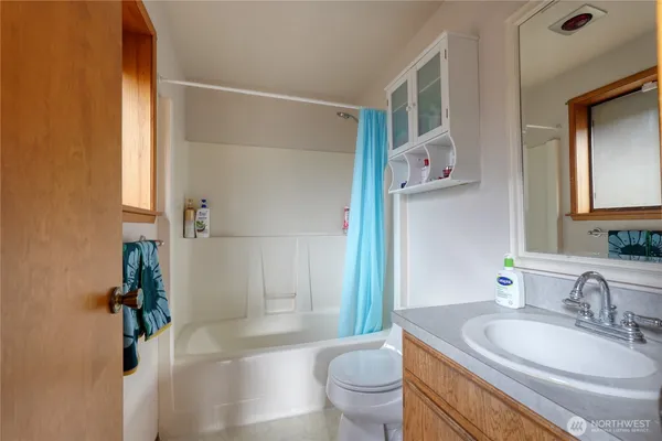 a bathroom with a granite countertop sink toilet a mirror and shower